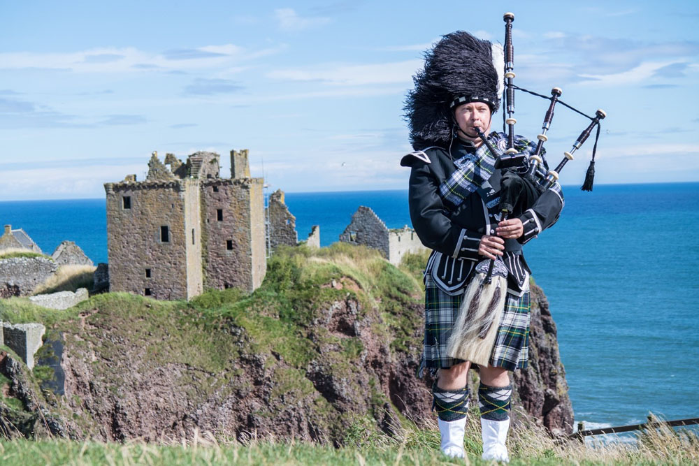 Traditioneller Schottischer Dudelsackspieler beim Dunnottar Castle in Stonehaven