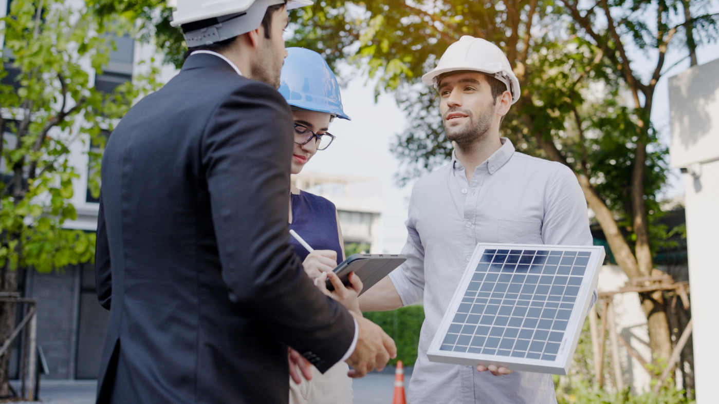 An energy consultant for buildings with a federal certificate explains the various solar energy options to potential customers.