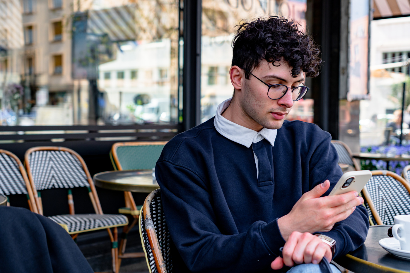 Junger Mann während trifft sich im Café mit Freunden, um im Französisch Auslandspraktikum in der Praxis Französisch zu lernen